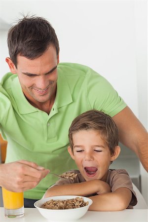 simsearch:400-06871178,k - Father giving cereal to his son in the kitchen Stock Photo - Budget Royalty-Free & Subscription, Code: 400-06888455