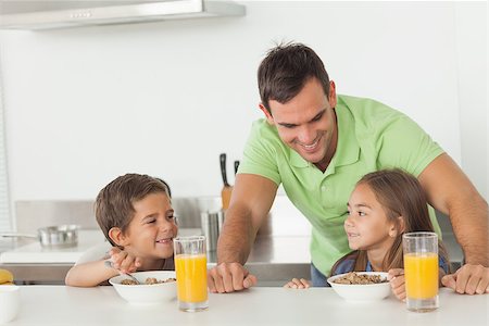Father chatting to his children while they are having breakfast in the kitchen Stock Photo - Budget Royalty-Free & Subscription, Code: 400-06888460