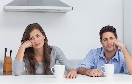 Tired couple sitting at the table with a cup of coffee in the kitchen Stock Photo - Budget Royalty-Free & Subscription, Code: 400-06888588