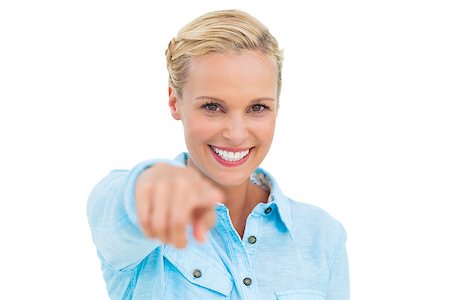 simsearch:400-06888942,k - Blonde pointing and smiling at camera against white background Photographie de stock - Aubaine LD & Abonnement, Code: 400-06888976