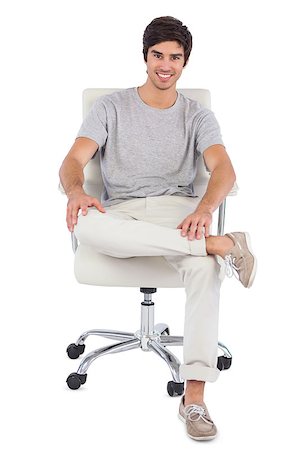 simsearch:400-06889148,k - Smiling man sitting on a swivel chair on a white background Foto de stock - Super Valor sin royalties y Suscripción, Código: 400-06889150