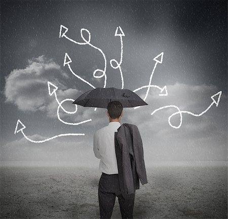 simsearch:400-04035704,k - Businessman looking at jumble up arrows holding umbrella in dark grey landscape Fotografie stock - Microstock e Abbonamento, Codice: 400-06889520