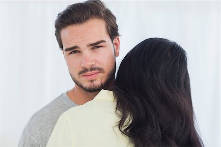 sad lover image backside - Woman giving hug to uninterested boyfriend looking at camera Stock Photo - Budget Royalty-Free & Subscription, Code: 400-06889715