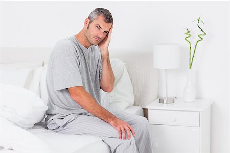 resaca - Anxious man holding his head in bed Foto de stock - Super Valor sin royalties y Suscripción, Código: 400-06889776