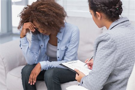 psychology couch - Woman sitting on therapists couch looking down with therapist taking notes Stock Photo - Budget Royalty-Free & Subscription, Code: 400-06880237