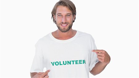 Man pointing to his volunteer tshirt on white background Stockbilder - Microstock & Abonnement, Bildnummer: 400-06880330