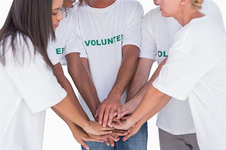 Happy volunteers putting hands together on white background Stockbilder - Microstock & Abonnement, Bildnummer: 400-06880344