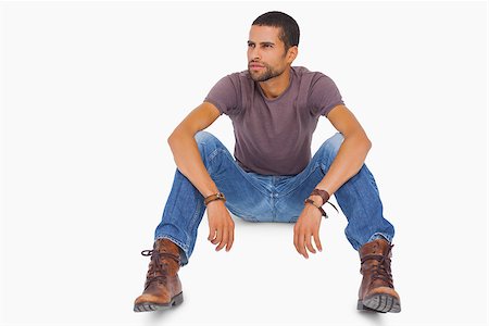 Handsome man sitting on floor and looking away on white background Stock Photo - Budget Royalty-Free & Subscription, Code: 400-06880575