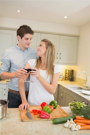 simsearch:400-05357733,k - Couple cooking and clinking wine glasses in kitchen Fotografie stock - Microstock e Abbonamento, Codice: 400-06881679