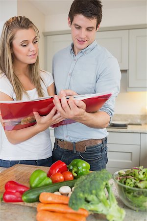 simsearch:400-04162443,k - Couple reading cookbook together in kitchen Fotografie stock - Microstock e Abbonamento, Codice: 400-06881707