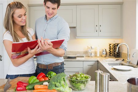 Couple reading cookbook together Stock Photo - Budget Royalty-Free & Subscription, Code: 400-06881708