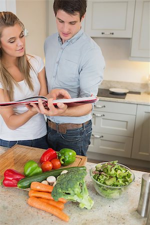 Couple reading cookery book in kitchen Stock Photo - Budget Royalty-Free & Subscription, Code: 400-06881709