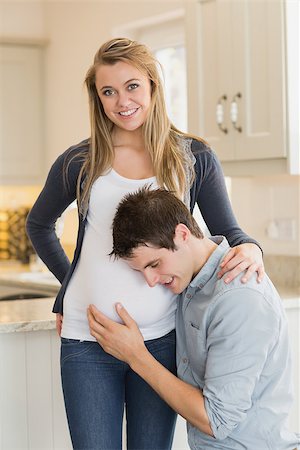 simsearch:400-07955632,k - Smiling pregnant woman with husband in kitchen Photographie de stock - Aubaine LD & Abonnement, Code: 400-06881744