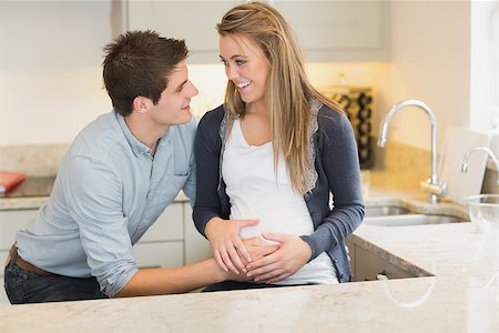 simsearch:400-07955632,k - Young happy pregnant woman with  husband in kitchen Photographie de stock - Aubaine LD & Abonnement, Code: 400-06881741