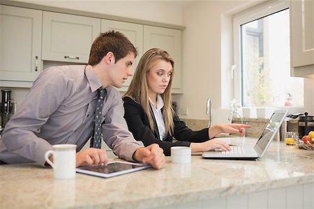 sophisticated home smile - Woman showing her husband something on the laptop in kitchen Stock Photo - Budget Royalty-Free & Subscription, Code: 400-06881817