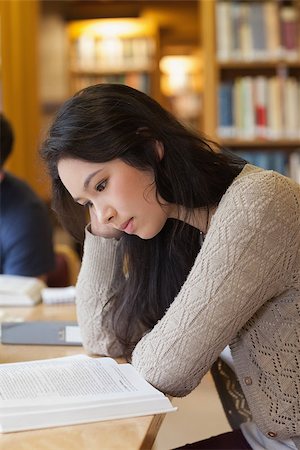 simsearch:400-07141917,k - Student sitting in a library and being concentrated while reading a book Stock Photo - Budget Royalty-Free & Subscription, Code: 400-06881924