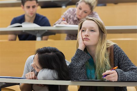 simsearch:400-04035793,k - Demotivated students sitting in a lecture hall with one girl napping in college Foto de stock - Super Valor sin royalties y Suscripción, Código: 400-06881959