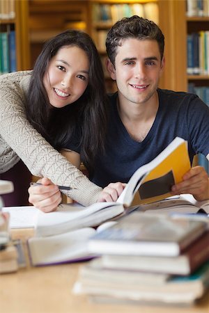 Two students sitting at a desk in a library while learning and having fun Stock Photo - Budget Royalty-Free & Subscription, Code: 400-06882046