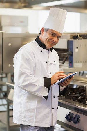 simsearch:400-07468062,k - Smiling chef using digital tablet in the kitchen Stockbilder - Microstock & Abonnement, Bildnummer: 400-06882093