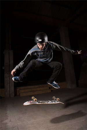 simsearch:6109-06781429,k - Skater wearing helmet doing kickflip trick in the skate park Foto de stock - Royalty-Free Super Valor e Assinatura, Número: 400-06882647