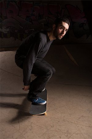 simsearch:6109-06781429,k - Skater bending his knees to prepare for a trick at the skate park Foto de stock - Royalty-Free Super Valor e Assinatura, Número: 400-06882655