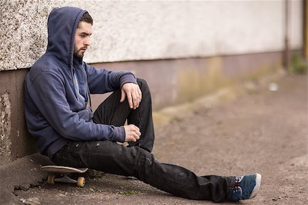 simsearch:6109-06781429,k - Skater taking a break outside the skate park sitting on his board Foto de stock - Royalty-Free Super Valor e Assinatura, Número: 400-06882651