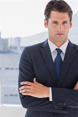 simsearch:400-07275251,k - Handsome businessman standing with arms crossed in a bright office Stock Photo - Budget Royalty-Free & Subscription, Code: 400-06882779