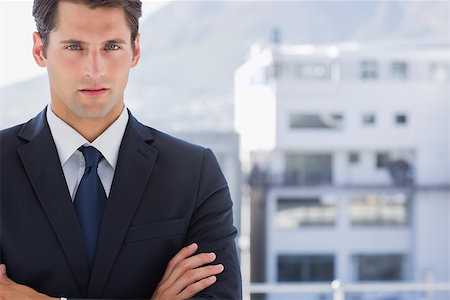 simsearch:400-07275251,k - Handsome businessman standing with arms folded in a bright office Stock Photo - Budget Royalty-Free & Subscription, Code: 400-06882780