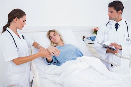 Doctor taking heartbeat of a hospitalized patient Stock Photo - Budget Royalty-Free & Subscription, Code: 400-06882926