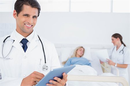 photo of patient in hospital in usa - Handsome doctor using digital tablet in front of patient and doctor Stock Photo - Budget Royalty-Free & Subscription, Code: 400-06882943