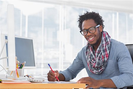 simsearch:400-06885294,k - Smiling designer drawing with a red pencil on a desk in a modern office Stockbilder - Microstock & Abonnement, Bildnummer: 400-06883035
