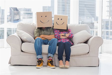 Silly workers wearing boxes on their heads with smiley faces on a couch Stock Photo - Budget Royalty-Free & Subscription, Code: 400-06883047