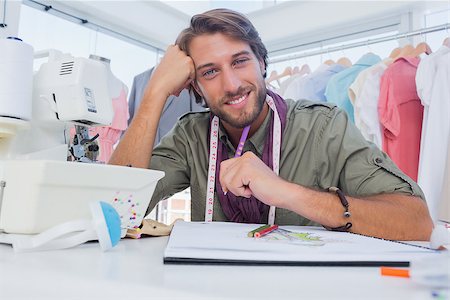 simsearch:400-06885526,k - Smiling designer working at his desk with pencils and sewing machine Stock Photo - Budget Royalty-Free & Subscription, Code: 400-06883169