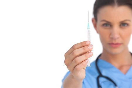 doctor preparing shot - Serious surgeon holding up a syringe on white background Stock Photo - Budget Royalty-Free & Subscription, Code: 400-06883865