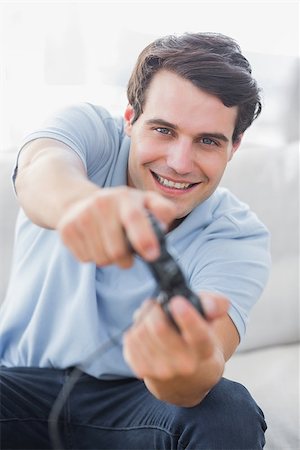 Portrait of a cheerful man playing video games in his living room Stock Photo - Budget Royalty-Free & Subscription, Code: 400-06890058