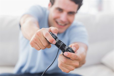 Portrait of a smiling man playing video games in his living room Stock Photo - Budget Royalty-Free & Subscription, Code: 400-06890059