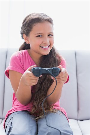 simsearch:400-06890095,k - Little girl playing video game on sofa in home Stock Photo - Budget Royalty-Free & Subscription, Code: 400-06890071