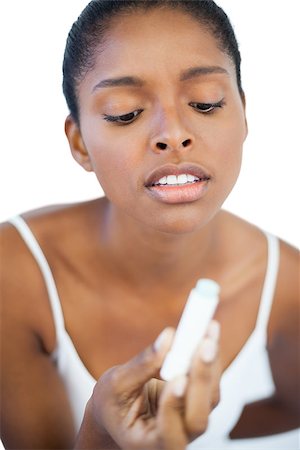 Woman looking at her lip balm on white background Stockbilder - Microstock & Abonnement, Bildnummer: 400-06890736