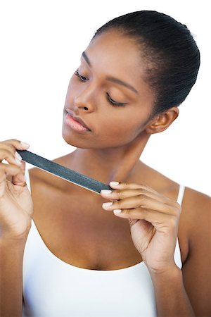 simsearch:400-06890736,k - Serious woman looking at her nail file on white background Stock Photo - Budget Royalty-Free & Subscription, Code: 400-06890731