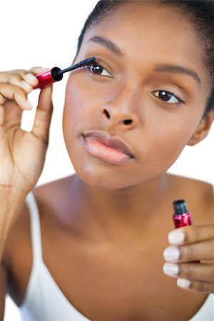 simsearch:400-06890736,k - Young woman using mascara for her eyelashes on white background Stock Photo - Budget Royalty-Free & Subscription, Code: 400-06890745