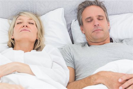 simsearch:400-06891122,k - Couple sleeping in their bed at home in bedroom Photographie de stock - Aubaine LD & Abonnement, Code: 400-06891118