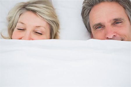 simsearch:400-06891122,k - Couple waking up under the covers at home in bed Photographie de stock - Aubaine LD & Abonnement, Code: 400-06891124