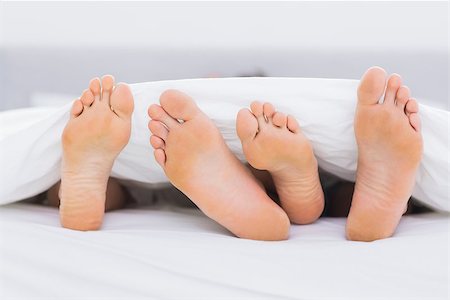 Pair of feet under the covers in a bed Stock Photo - Budget Royalty-Free & Subscription, Code: 400-06891121