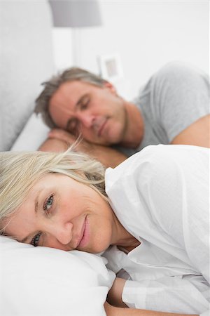 simsearch:400-06891122,k - Woman awake as her partner is sleeping in bed at home in bedroom Photographie de stock - Aubaine LD & Abonnement, Code: 400-06891135