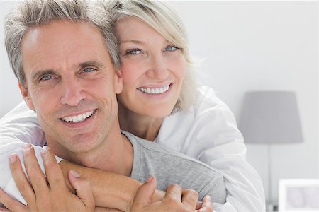 simsearch:400-06891126,k - Affectionate couple smiling at camera at home in bedroom Stock Photo - Budget Royalty-Free & Subscription, Code: 400-06891195