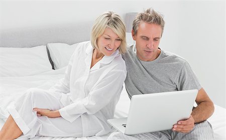 simsearch:400-06891122,k - Couple using their laptop at home in bedroom Photographie de stock - Aubaine LD & Abonnement, Code: 400-06891199