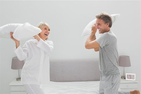 simsearch:400-06891126,k - Couple having a pillow fight at home in bedroom Stock Photo - Budget Royalty-Free & Subscription, Code: 400-06891207