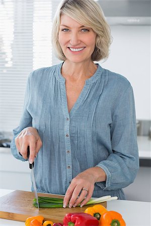 simsearch:400-06891385,k - Happy woman preparing vegetables at the ktichen counter Stock Photo - Budget Royalty-Free & Subscription, Code: 400-06891273