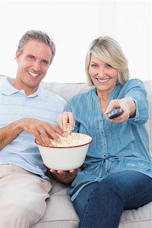 simsearch:400-04268918,k - Couple watching tv and eating popcorn on the sofa at home in living room Stockbilder - Microstock & Abonnement, Bildnummer: 400-06891338
