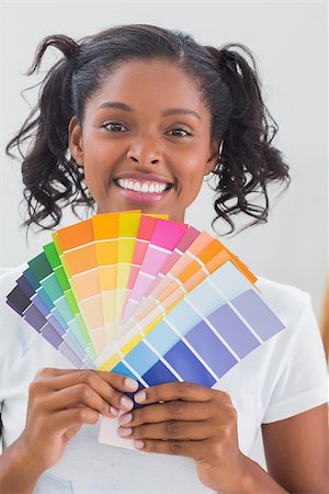 simsearch:400-07834992,k - Smiling woman showing colour charts against a white wall Fotografie stock - Microstock e Abbonamento, Codice: 400-06891488